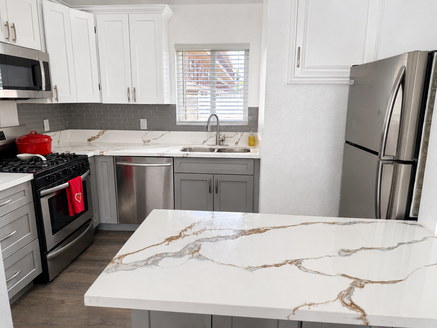 Remodeled kitchen with quartz island and shaker cabinetry